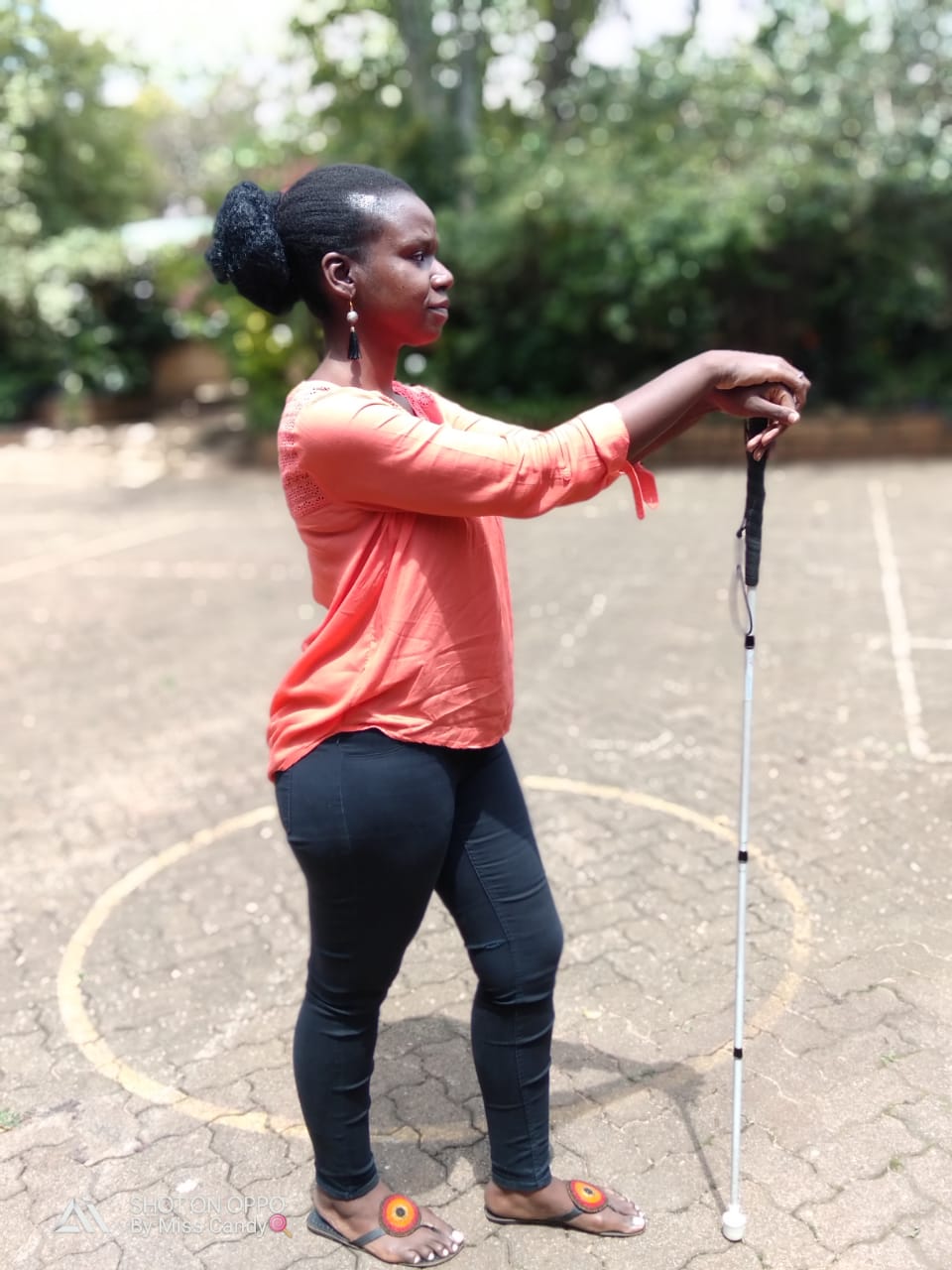 Ability Program Manager Crystal Asige poses for a picture while standing with a white cane